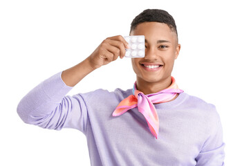 Happy African-American guy with blister of chewing gum on white background