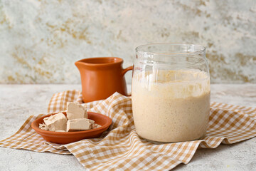 Jar and bowl with fresh sourdough on table