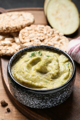 Bowl with tasty baba ghanoush and rice crackers on table, closeup