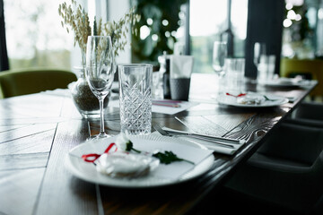 Beautiful decoration of a festive table with crockery and cutlery, decorated with flowers and ribbons. Festive table setting.