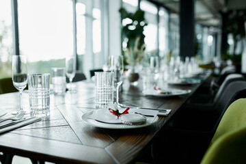 Beautiful decoration of a festive table with crockery and cutlery, decorated with flowers and ribbons. Festive table setting.