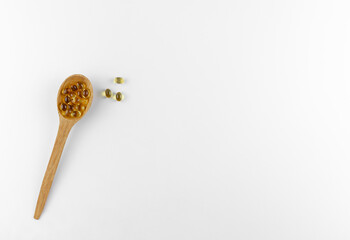 vitamin d capsules on a wooden spoon

