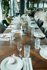 Beautiful decoration of a festive table with crockery and cutlery, decorated with flowers and ribbons. Festive table setting.