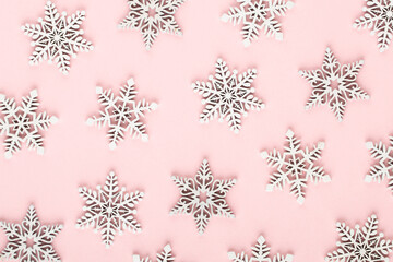 Christmas background. White snow decorations on a pink background.