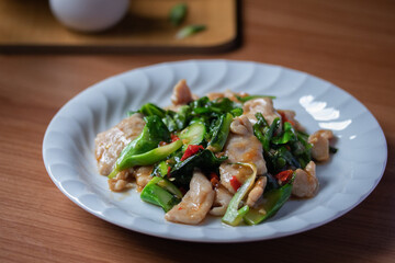 Stir-fried pork with kale and chilli in a white plate