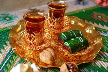 Turkish sweet baklava on metal tray with Turkish tea