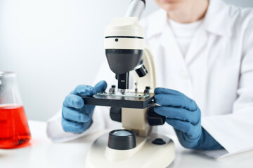Fototapeta premium woman scientist looking through a microscope laboratory research diagnostics