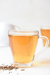 Glass cup of tasty hojicha green tea on white background