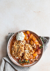 Ceramic plate with tasty plum crumble dessert served with vanilla ice cream and herbs. Top view.