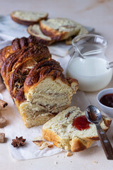 Cinnamon and brown sugar babka or brioche bread with jam and milk. Homemade pastry for breakfast.