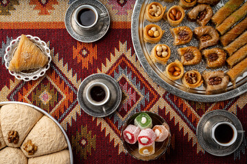 Turkish coffee and sweets served on colorful patterned carpet