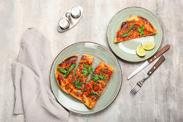 Plates with tasty Turkish Pizza on grunge background