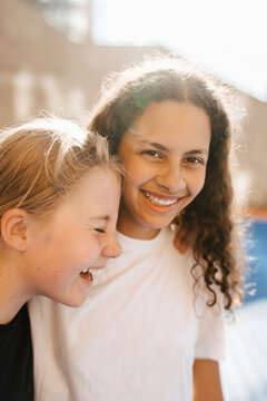 Portrait of girl laughing with female friends at sports court