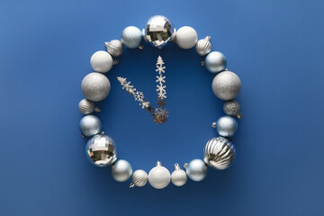 Clock made of Christmas decor on blue background