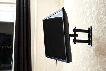 Swivel TV bracket LED display. Side view. X-shaped red fasteners. Black color. Multiplanar. Hangs...