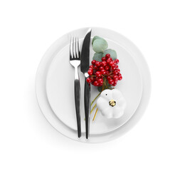 Thanksgiving table setting with pumpkin pepper shakers, cutlery, rowan and eucalyptus branch on white background