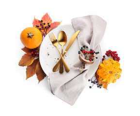 Thanksgiving table setting with pumpkins, berries and autumn leaves on white background