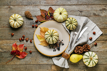 Thanksgiving table setting with autumn decor on wooden background