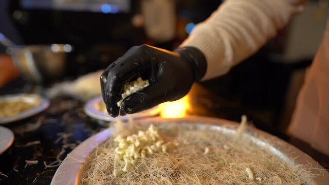 Sprinkle cheese on the kunafa - making konafa - with animal ghee