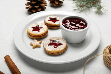 Plate with tasty Linzer cookies and jam on white background