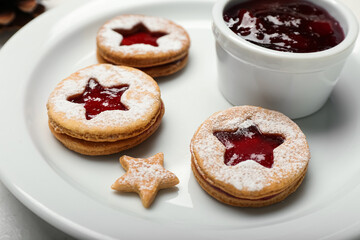 Plate with tasty Linzer cookies and jam, closeup