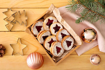 Box with tasty Linzer cookies and Christmas decor on wooden background