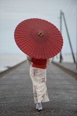 和傘をさして歩いている着物を着た女性