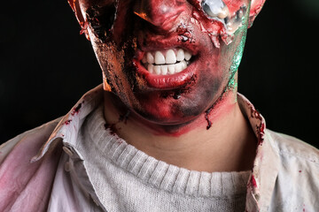 Scary zombie on dark background, closeup