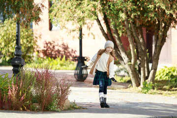 Fototapeta na wymiar cute girl dressed in autumn clothes on a walk