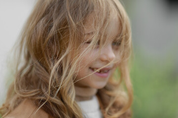 portrait of a cute girl dressed in autumn clothes with hair tangled from the wind