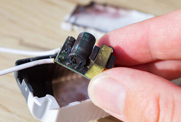 Fototapeta premium Burnt and soot-charred PCB for LED lighting. Possible cause of fire, short circuit.