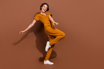 Fototapeta na wymiar Full body photo of cheerful cool positive woman dance enjoy free time weekend isolated on brown color background