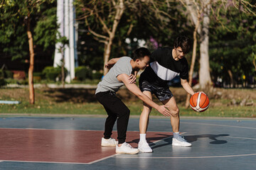 Sports and recreation concept two male basketball players enjoying playing basketball together on the sports ground