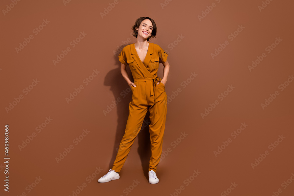 Poster Full length photo of cheerful charming nice woman hands pockets good mood isolated on brown color background