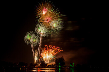 Naklejka premium Fireworks with beautiful colorful flowers on a dark sky background.