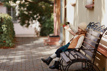 dressed in autumn clothes cute girl holding rowan branch in her hands