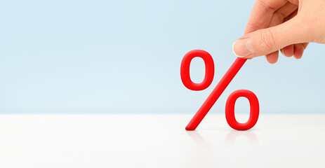 female hand puts a percent sign on a light background