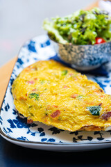 Omelet with ham, tomato and green salad