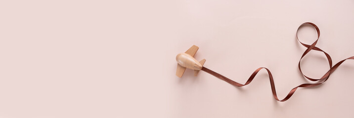 small wooden toy airplane carries a figure-shaped ribbon 8