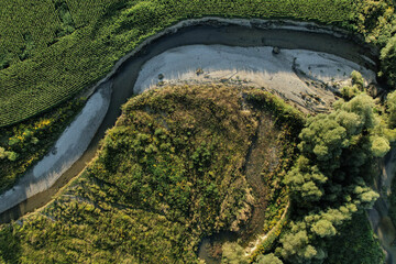 Top down view of a dried up sandy river bed among the farm fields in a rural area