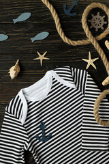 Marine concept of baby clothes on wooden background