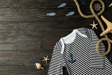 Marine concept of baby clothes on wooden background