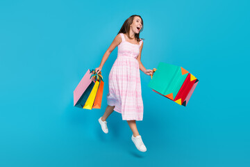 Full size photo of brunette haired stylish attractive beautiful amazed lady jump sale bags crazy isolated on blue color background