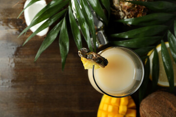 Pina colada cocktail and ingredients on wooden background