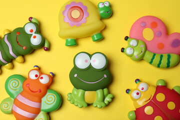 Cute baby toys on yellow background, top view