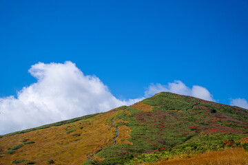 宮城県栗原市、秋田県湯沢市、雄勝郡東成瀬村、岩手県一関市にある栗駒山を紅葉の時期に登山する風景A view of climbing Mt. Kurikoma in Kurihara City, Miyagi Prefecture, Yuzawa City, Akita Prefecture, during the autumn foliage season.