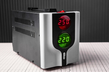 modern voltage regulator standing on the table in the workshop