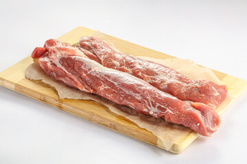 Raw pork tenderloin over board