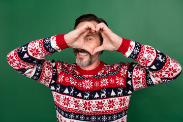 Photo portrait man in sweater smiling looking in heart sign on date playful isolated pastel green...