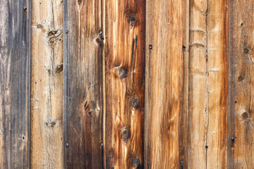 Wooden background of brown boards with visible knots